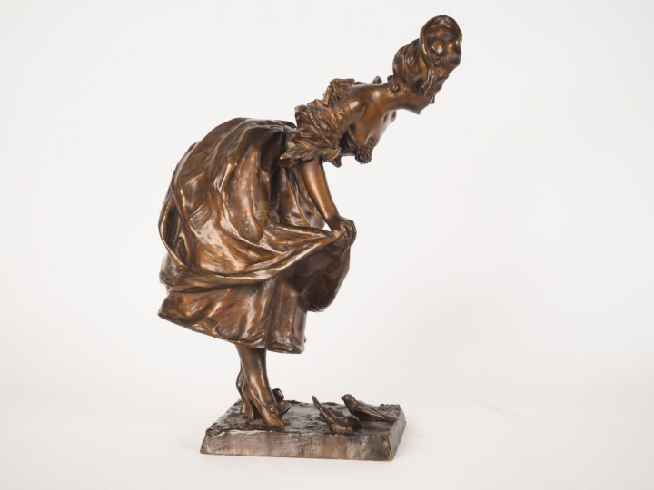 BRUYNEEL. "Jeune fille aux oiseaux". Sculpture en bronze à patine méda