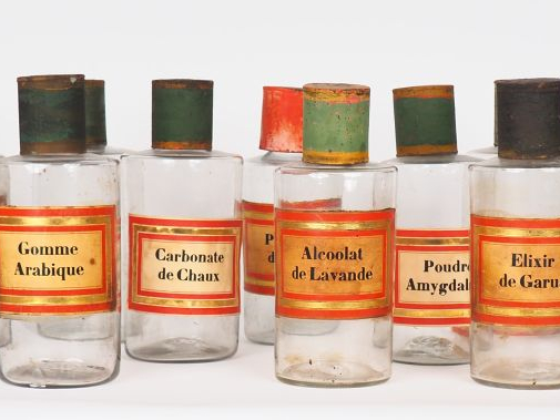 Suite de 14 pots de pharmacie en verre et tôle polychrome. H. 24 cm.