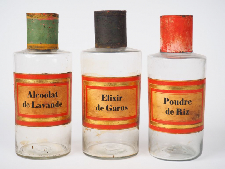 Suite de 14 pots de pharmacie en verre et tôle polychrome. H. 24 cm.