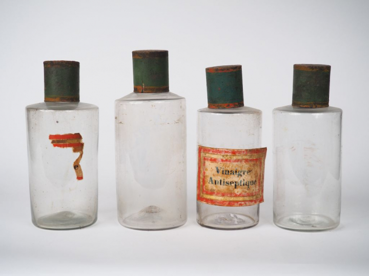 Suite de 14 pots de pharmacie en verre et tôle polychrome. H. 24 cm.