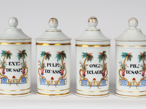 Suite de 12 pots de pharmacie en porcelaine polychrome. H. 24,5 cm.