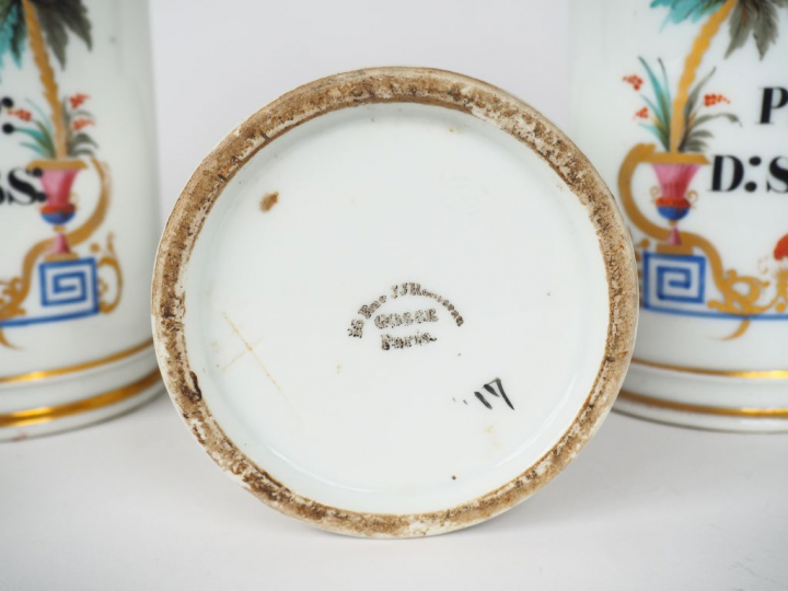 Suite de 12 pots de pharmacie en porcelaine polychrome. H. 24,5 cm.