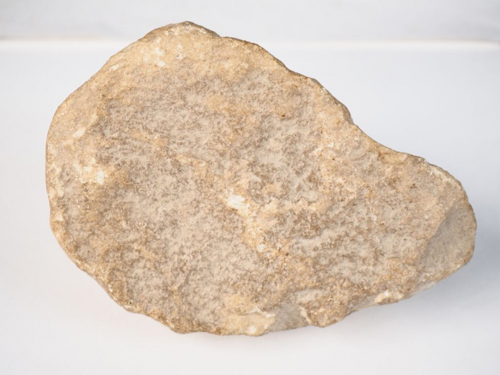 Tête en pierre calcaire sculptée aux yeux fendus et à la chevelure bou