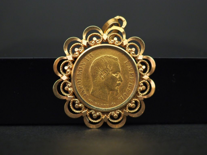 Pendentif ajouré en or jaune, serti en son centre d’une pièce de 10 fr