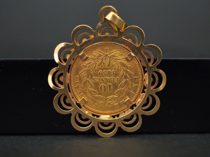 Pendentif ajouré en or jaune, serti en son centre d’une pièce de 10 fr