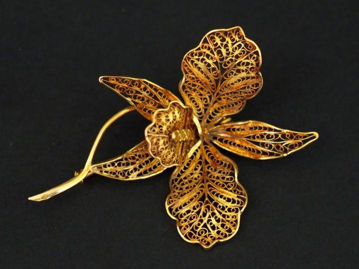 Broche en or jaune, en forme de fleur épanouie, à décor de filigranes.