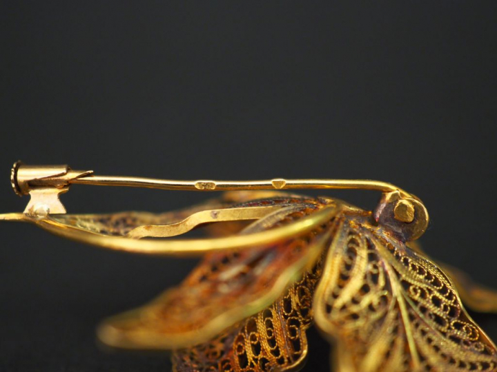 Broche en or jaune, en forme de fleur épanouie, à décor de filigranes.
