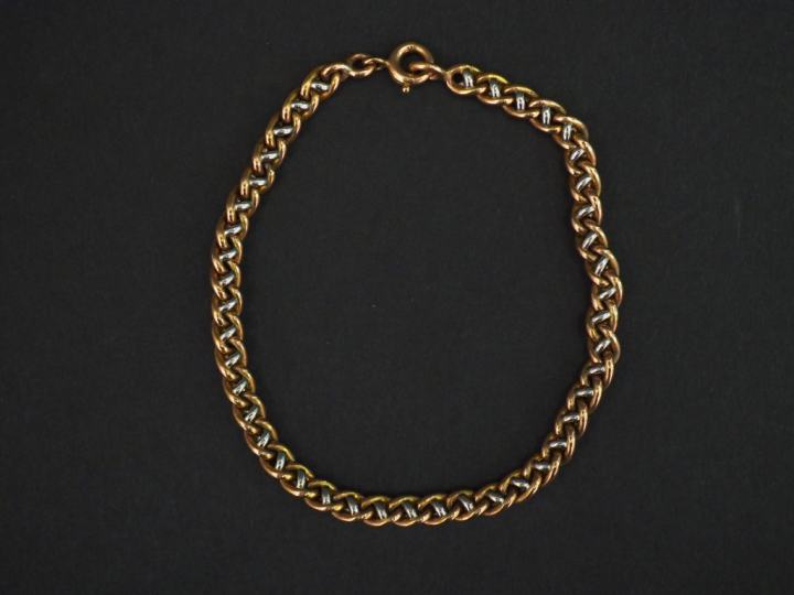 Bracelet articulé deux tons d’or, maille tressée. Long. 17,5 cm Poids.