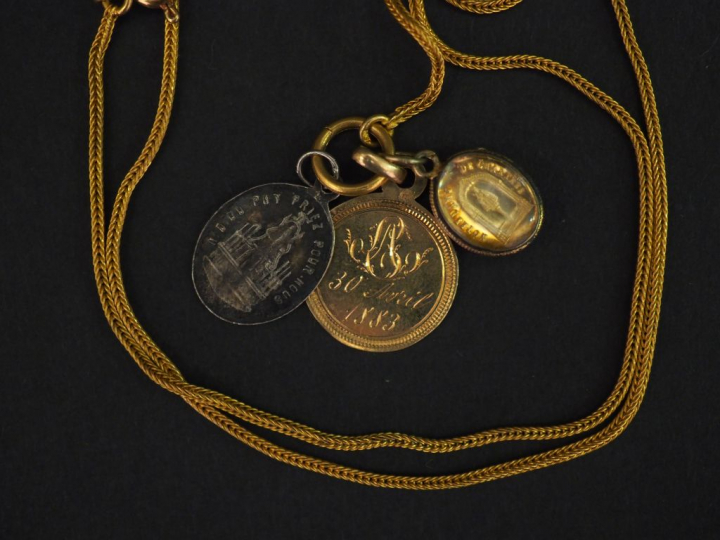 	Chaine en or jaune, maille ronde.  Le fermoir orné de trois différent