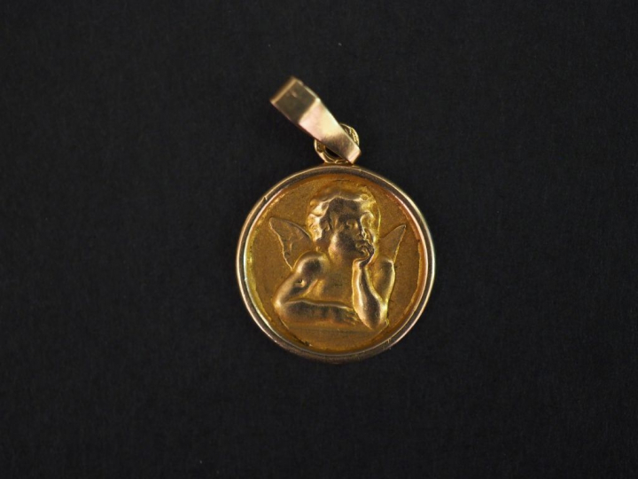 Petite médaille en or jaune, à décor d’angelot. Diam. 1,3 cm Poids. 0,