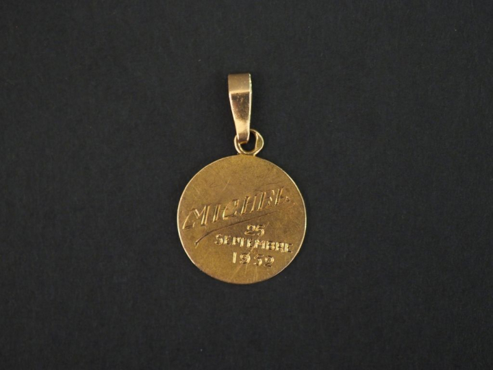 Petite médaille en or jaune, à décor d’angelot. Diam. 1,3 cm Poids. 0,