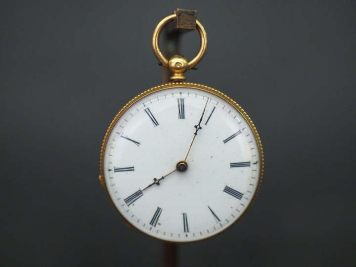 	Montre de col en or jaune. Le revers, à décor de médaillon feuillagé 
