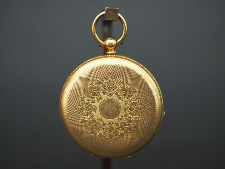	Montre de col en or jaune. Le revers, à décor de médaillon feuillagé 