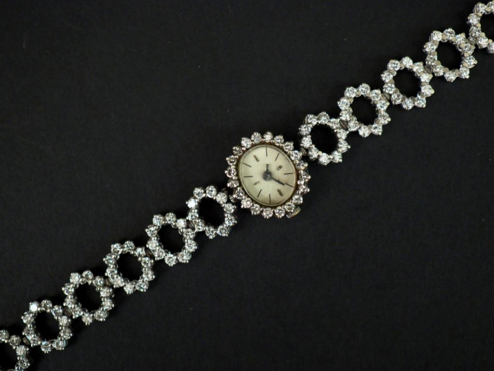 	Montre bracelet de dame en or blanc et diamants. Cadran ovale à index