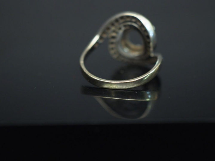 Bague dite "tourbillon" en or blanc, sertie en son centre d'un diamant