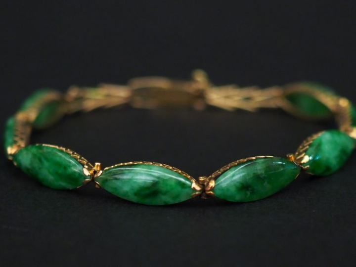 Bracelet articulé en or jaune, à décor de maillons ovales sertis de ja