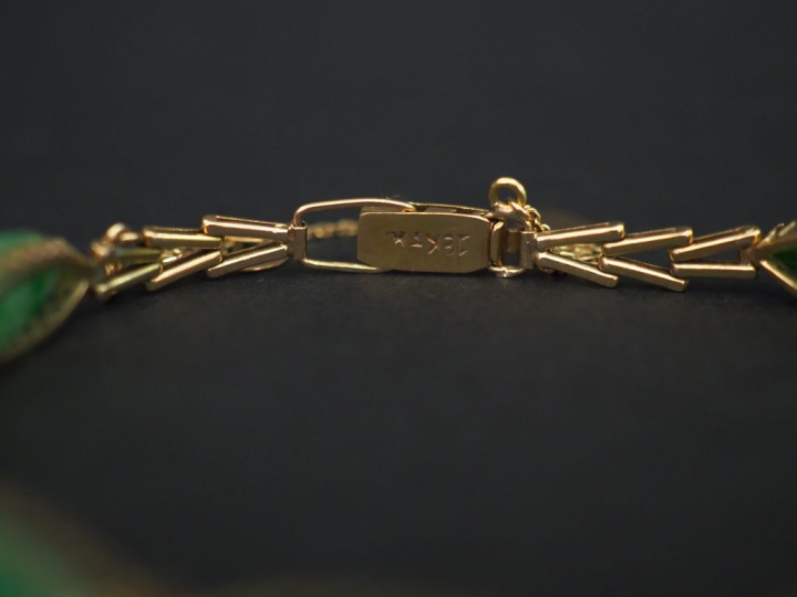 Bracelet articulé en or jaune, à décor de maillons ovales sertis de ja