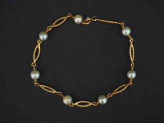 Vente aux enchères Bracelet en or jaune, à décor de maillons ovales et perles alternés. L