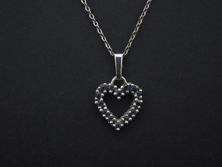 	Pendentif en or blanc en forme de coeur, serti de petits saphirs. On 