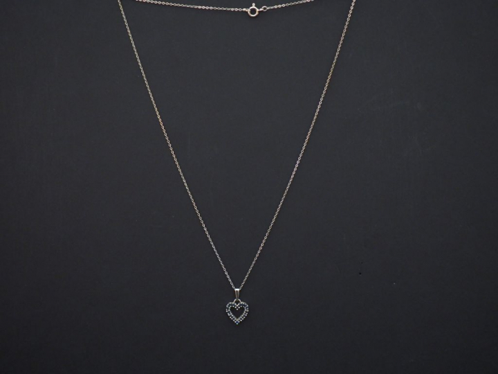 	Pendentif en or blanc en forme de coeur, serti de petits saphirs. On 