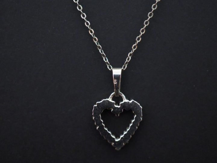 	Pendentif en or blanc en forme de coeur, serti de petits saphirs. On 
