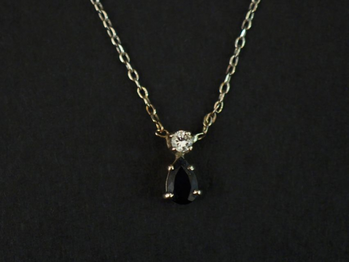 	Pendentif et sa chaine en or blanc, serti d’un saphir surmonté d’un p