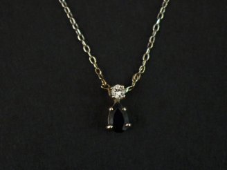 Vente aux enchères 	Pendentif et sa chaine en or blanc, serti d’un saphir surmonté d’un p