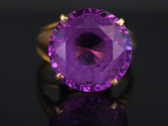 Vente aux enchères 	Bague en or jaune, sertie en son centre d’une améthyste. Jolie montur