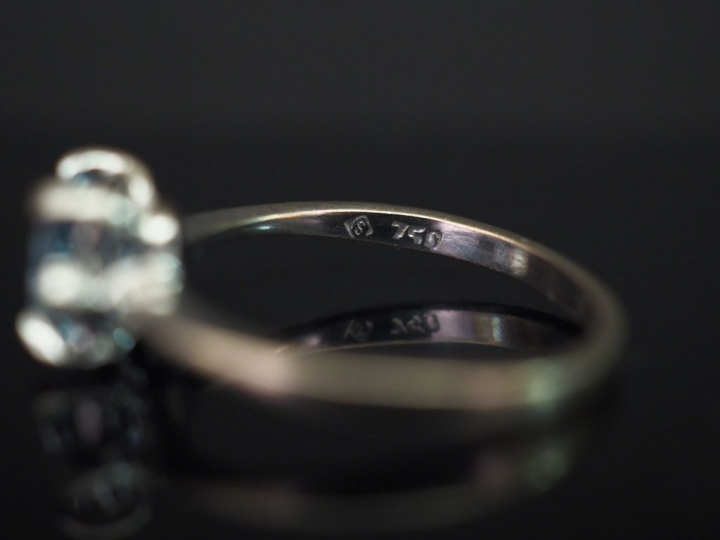 	Bague en or blanc, sertie en son centre d’une aigue marine épaulé de 