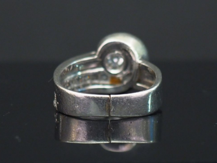 Bague moderne dite « tourbillon » en or blanc, sertie en son centre d’