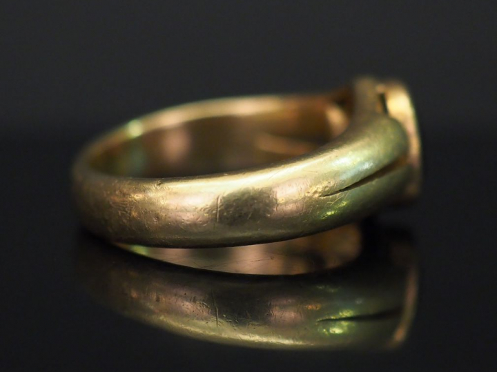 Bague jonc en or jaune, sertie en son centre d’une pierre rouge. TDD. 