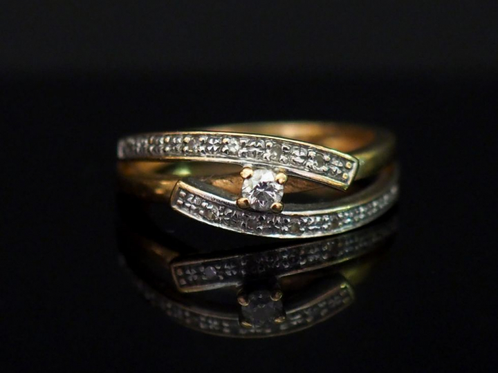 Bague en or jaune, sertie d’un diamant central et de petits diamants. 