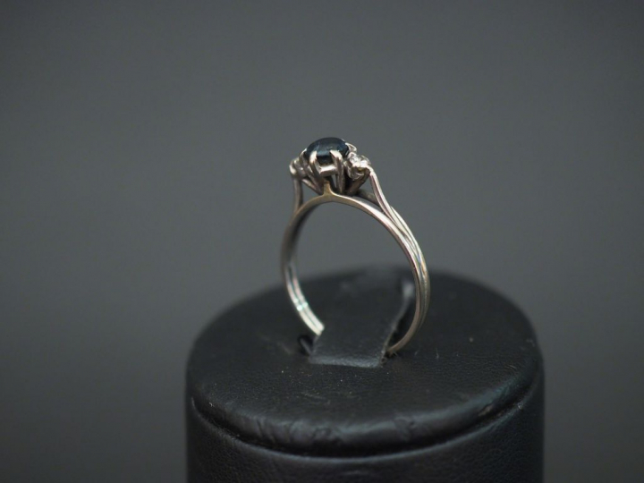 	Bague en or blanc, sertie en son centre d’un saphir épaulé de deux pe