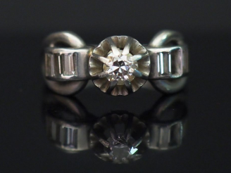 Vente aux enchères Bague de style 1900 en or blanc, sertie en son centre d’un diamant tai