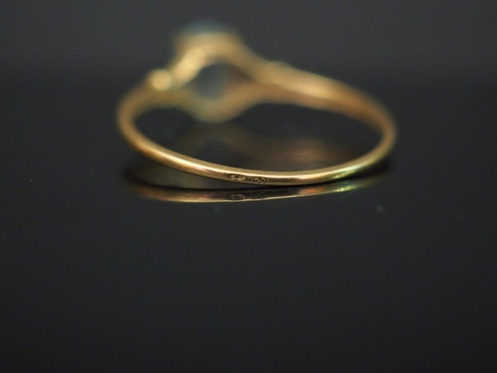 	Petite bague en or jaune, sertie en son centre d’une pierre bleue. TD