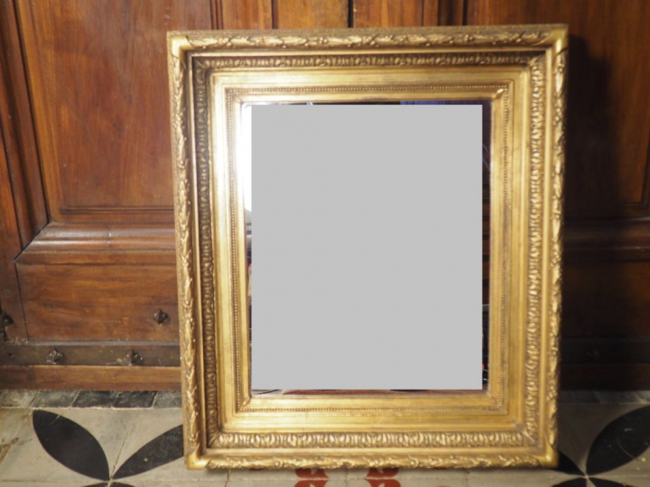 Glace, cadre en stuc doré.  Dim. 74 x 64 cm