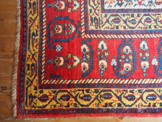Vente aux enchères Grand tapis d'orient à fond clair et rouge. Dim. 570 x 310 cm.