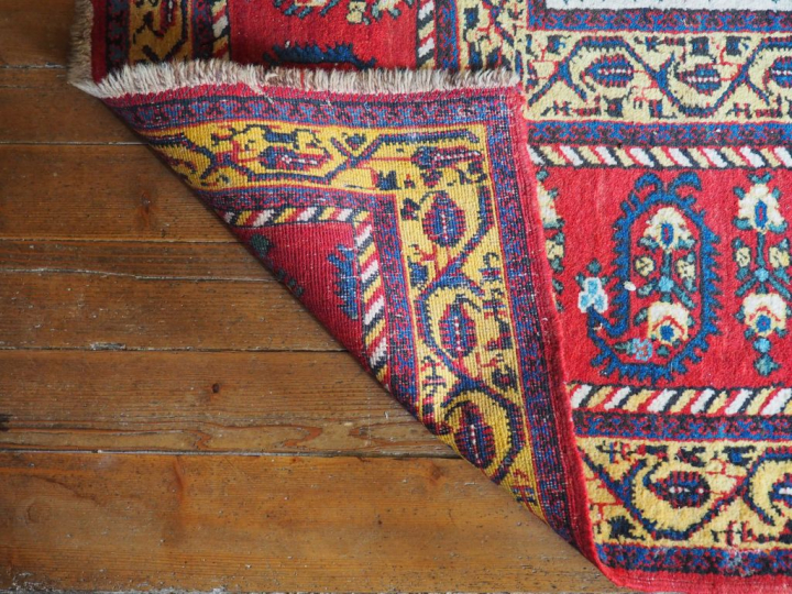 Grand tapis d'orient à fond clair et rouge. Dim. 570 x 310 cm.