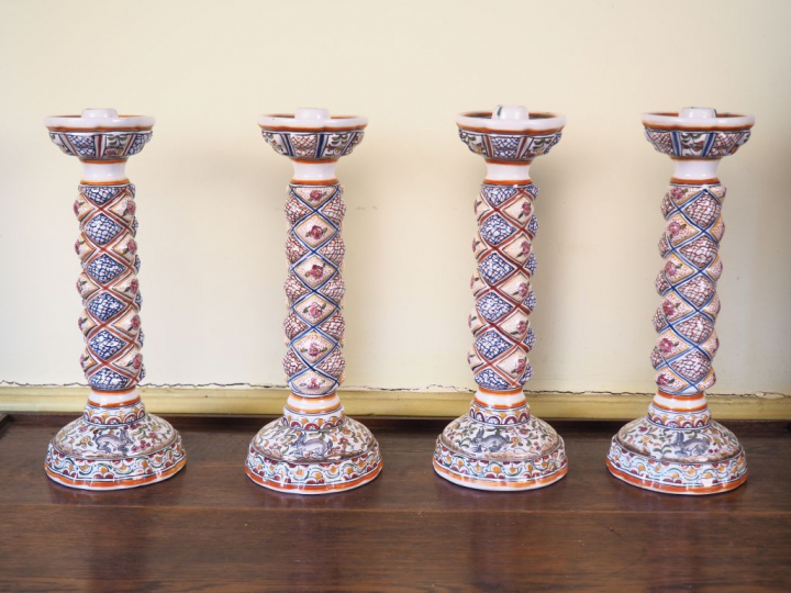 Suite de 4 bougeoirs en porcelaine polychrome du Portugal. H. 33 cm.