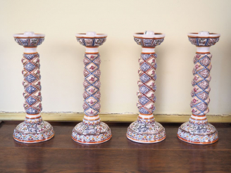 Vente aux enchères Suite de 4 bougeoirs en porcelaine polychrome du Portugal. H. 33 cm.