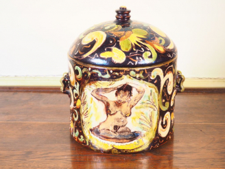Vente aux enchères Pot couvert en terre vernissée à décor de jeune femme et de feuillage.