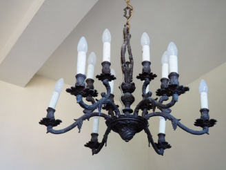 Vente aux enchères Lustre en métal à patine brune éclairant à 12 lumières.