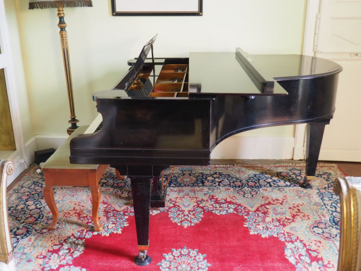 Piano quart de queue Berchstein en bois laqué noir cadre fer.