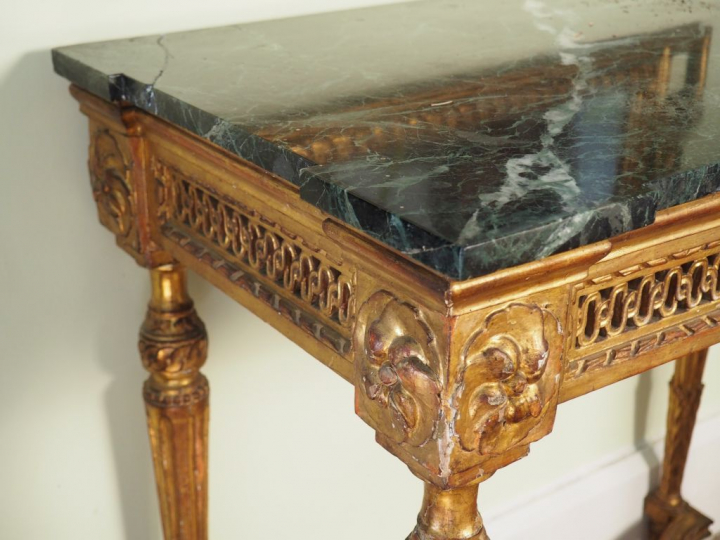 Console Louis XVI en bois sculpté doré et ajouré, quatre pieds cannelé