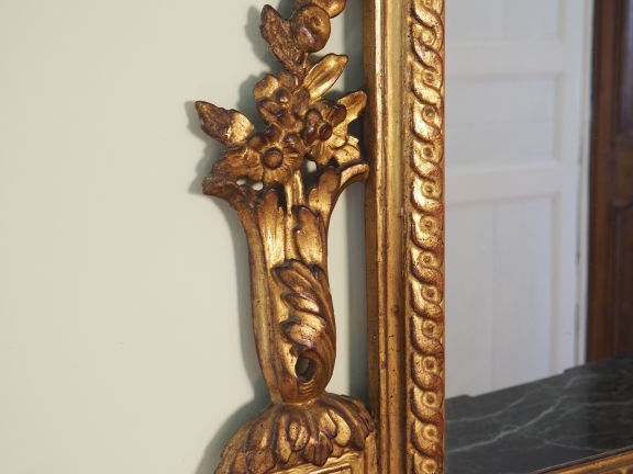 Glace Louis XVI en bois sculpté doré et ajouré à décor de piastres de 