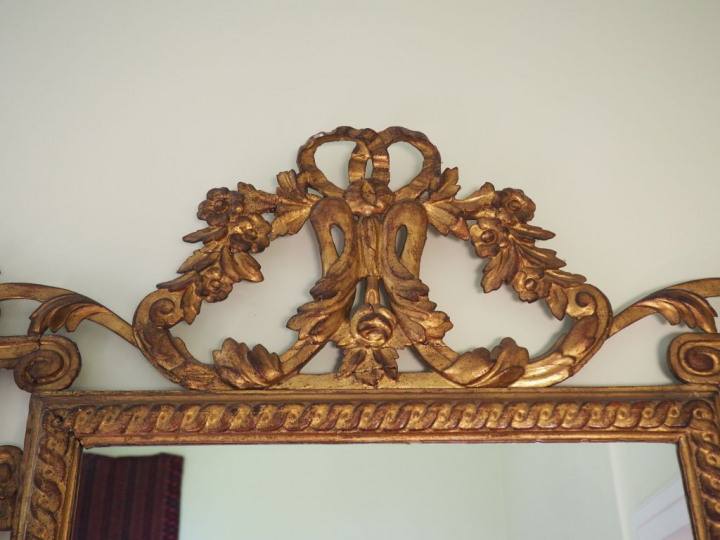 Glace Louis XVI en bois sculpté doré et ajouré à décor de piastres de 