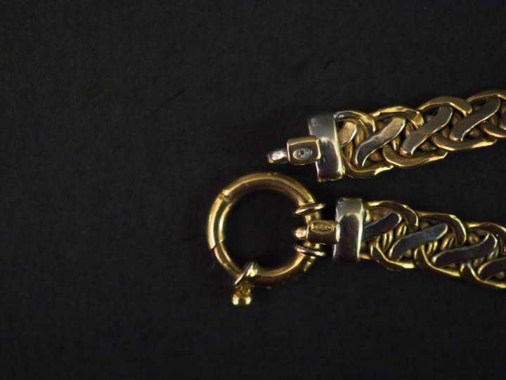 Bracelet articulé deux tons d'or, maille tressée.  Long. 19,5 cm Poids
