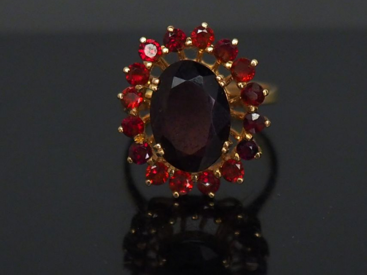 	Bague marguerite en or jaune, sertie d’un grenat central entouré de s