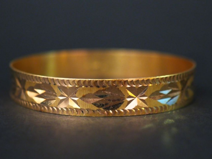 Bracelet jonc en or jaune, à décor de motifs géométriques. Largeur. 1,