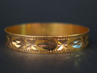 Vente aux enchères Bracelet jonc en or jaune, à décor de motifs géométriques. Largeur. 1,